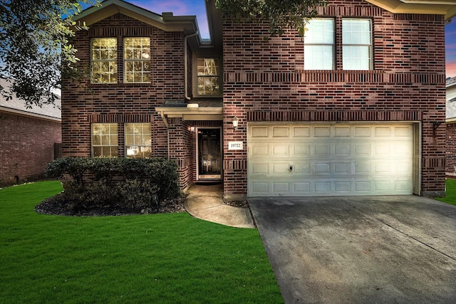 front of property with a garage and a lawn