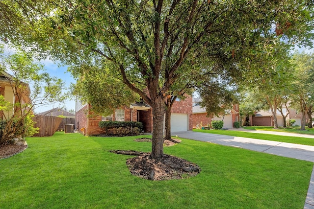 obstructed view of property featuring a garage, a front yard, and central AC unit