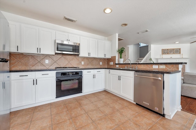 kitchen with sink, white cabinets, decorative backsplash, kitchen peninsula, and stainless steel appliances