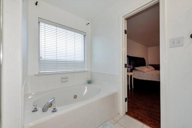 bathroom with a tub to relax in and tile patterned flooring