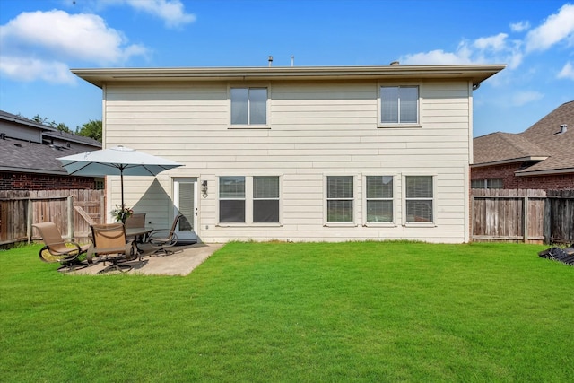 rear view of property featuring a patio and a yard