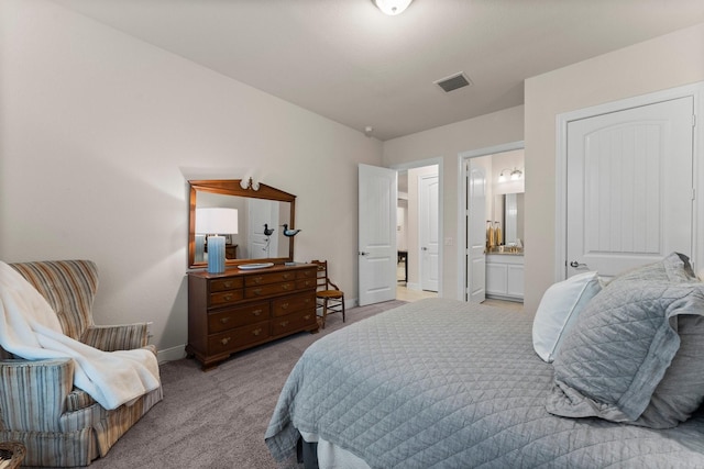 bedroom featuring light carpet and ensuite bath