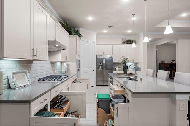 kitchen with decorative light fixtures, stainless steel appliances, white cabinetry, and sink