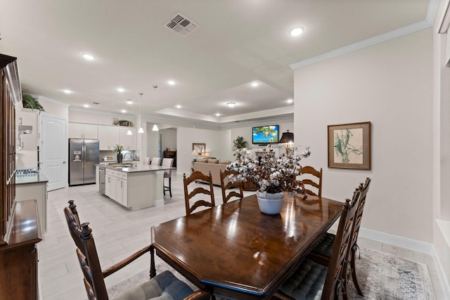 dining space with ornamental molding and sink