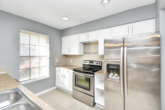 kitchen featuring light tile patterned floors, stainless steel appliances, white cabinetry, and a healthy amount of sunlight