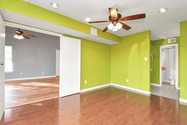 empty room featuring hardwood / wood-style floors, a textured ceiling, and ceiling fan