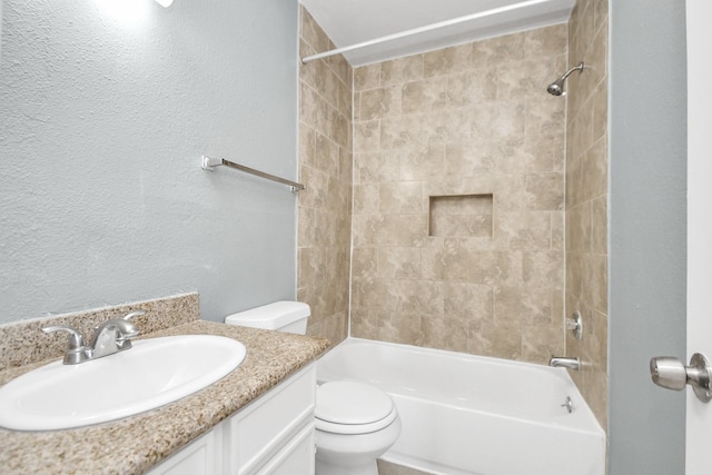 full bathroom featuring vanity, tiled shower / bath combo, and toilet