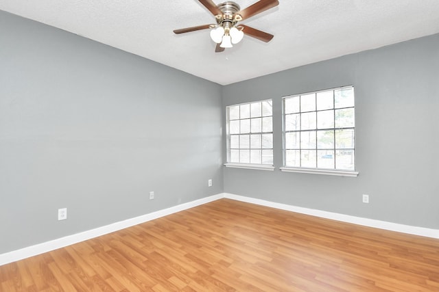 unfurnished room with ceiling fan, light wood-type flooring, and a textured ceiling