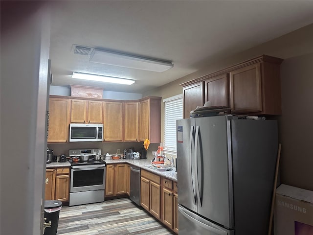 kitchen featuring sink, stainless steel appliances, and light hardwood / wood-style flooring