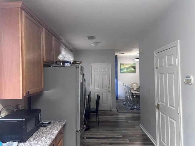 kitchen featuring stainless steel fridge and dark hardwood / wood-style floors