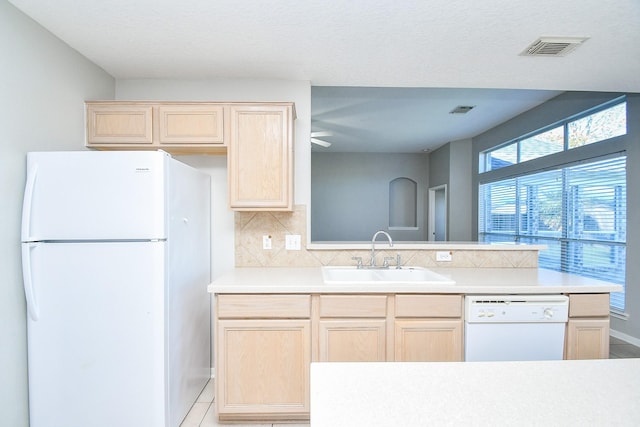 kitchen featuring sink, light brown cabinets, white appliances, light tile patterned floors, and decorative backsplash