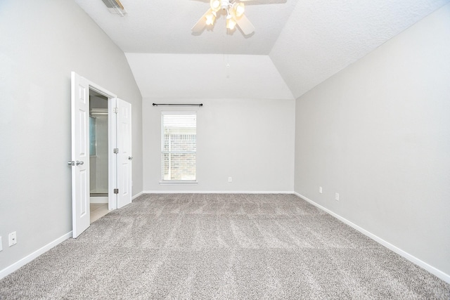 unfurnished bedroom with ceiling fan, vaulted ceiling, carpet, and a textured ceiling