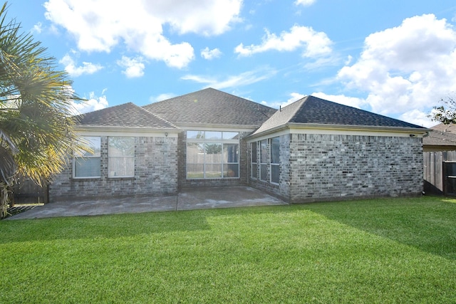 rear view of property with a patio and a lawn