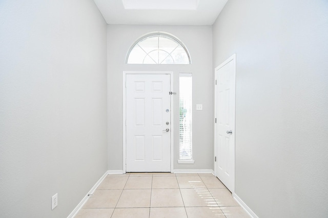 foyer featuring a towering ceiling and light tile patterned floors