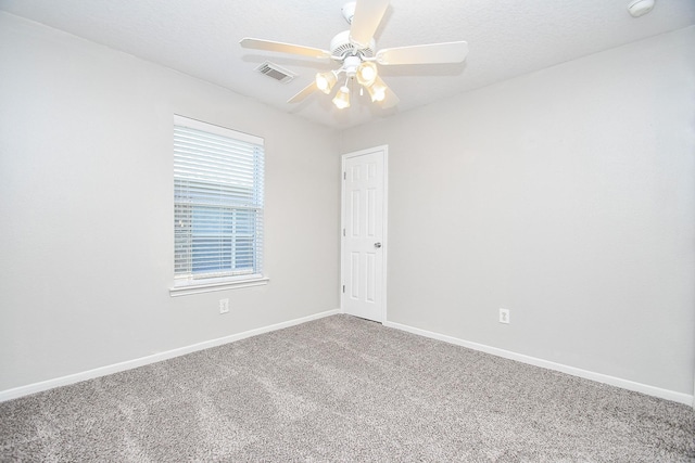 unfurnished room with ceiling fan and carpet