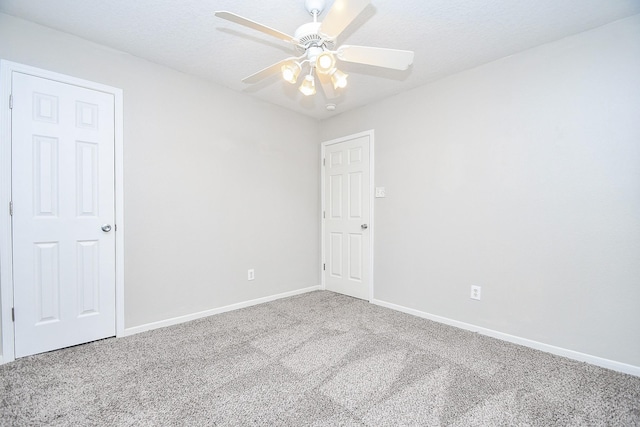 unfurnished room with a textured ceiling, carpet floors, and ceiling fan