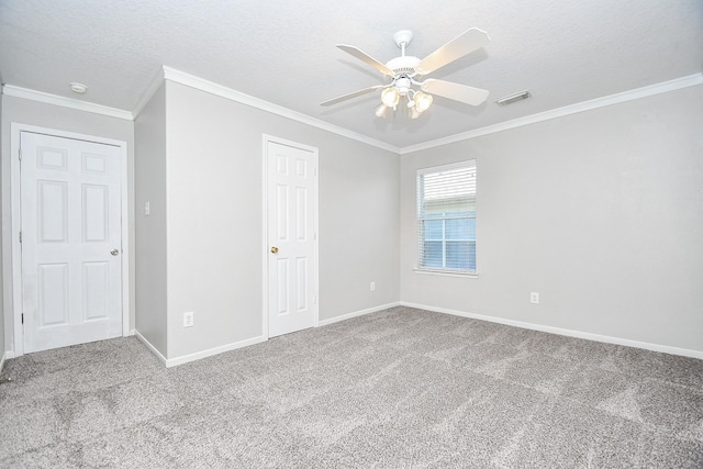 carpeted empty room featuring ceiling fan, crown molding, and a textured ceiling