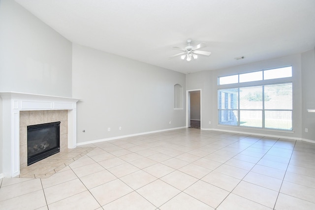 unfurnished living room featuring a tile fireplace, ceiling fan, and light tile patterned floors