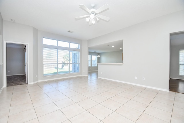 spare room with ceiling fan and light tile patterned floors