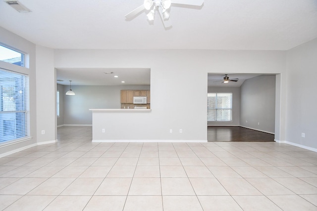 spare room with ceiling fan and light tile patterned floors