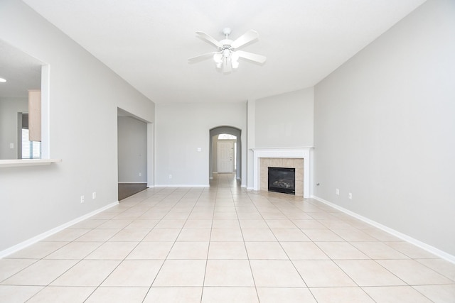 unfurnished living room featuring a fireplace, ceiling fan, and light tile patterned floors