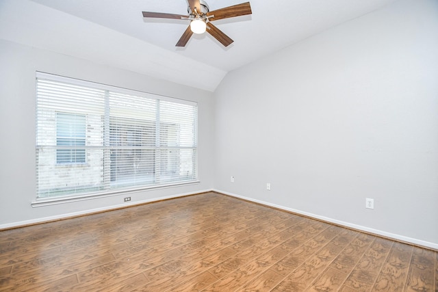 empty room with a wealth of natural light, ceiling fan, hardwood / wood-style floors, and lofted ceiling