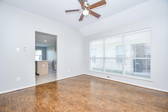 unfurnished room featuring ceiling fan, vaulted ceiling, and light wood-type flooring