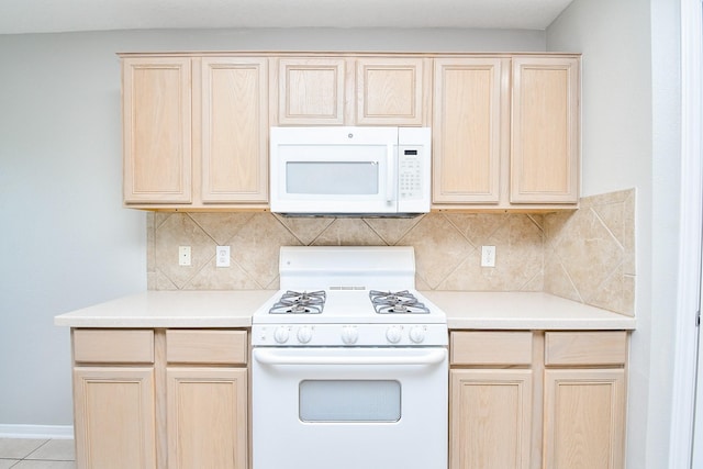 kitchen featuring light brown cabinets, white appliances, decorative backsplash, and light tile patterned floors