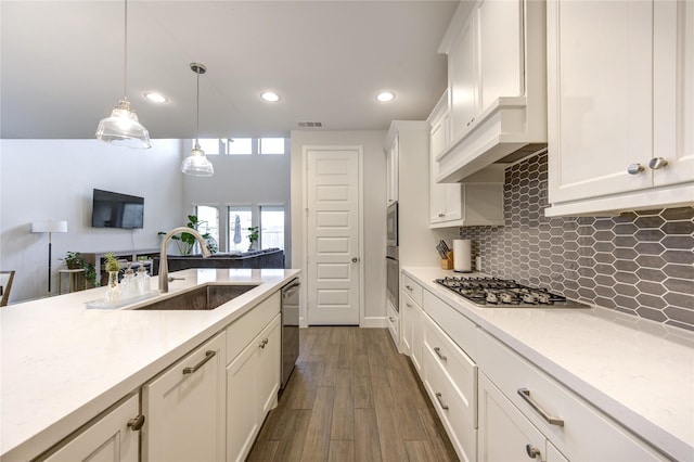 kitchen featuring pendant lighting, light stone counters, sink, and stainless steel appliances