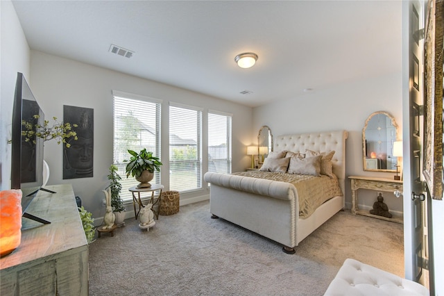 bedroom with light carpet and multiple windows