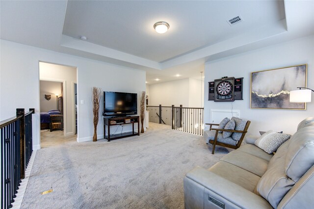 living room featuring carpet floors and a raised ceiling