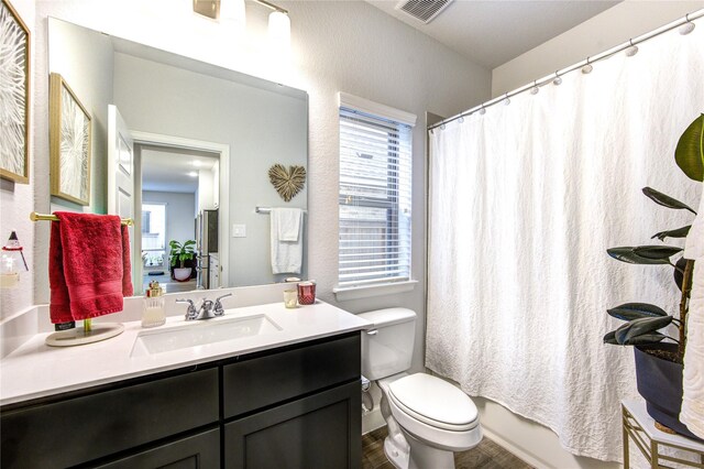 full bathroom with vanity, toilet, and shower / tub combo with curtain