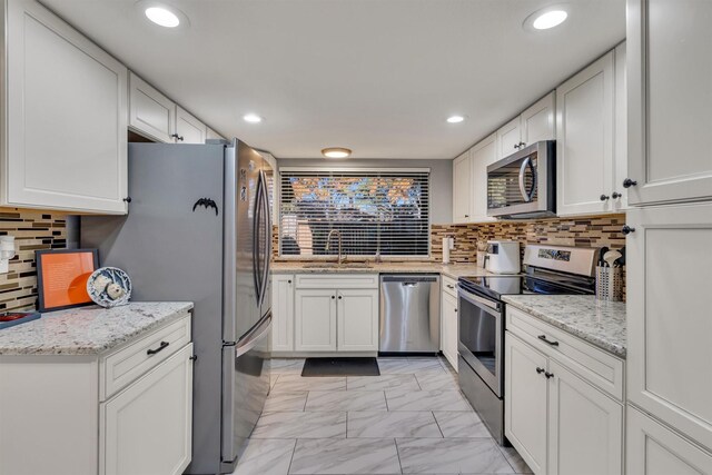 3110 Pin Oak Ct, Farmers Branch, TX 75234 - kitchen featuring white cabinets, backsplash, appliances with stainless steel finishes, marble finish floor, and recessed lighting