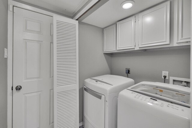 laundry area with separate washer and dryer, cabinets, and ornamental molding