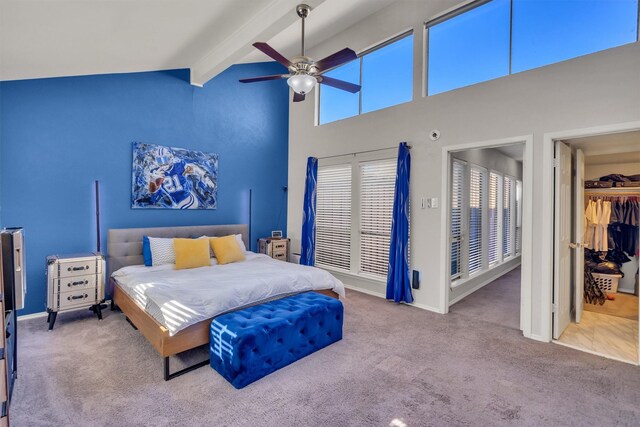 bedroom with carpet flooring, ceiling fan, a spacious closet, beamed ceiling, and a closet