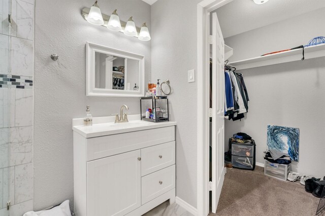 bathroom featuring a shower and vanity