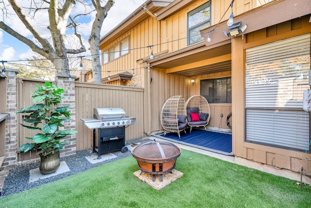 wooden deck featuring a grill, a yard, and an outdoor fire pit