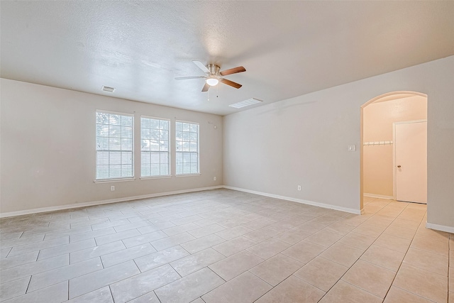 spare room with light tile patterned floors, a textured ceiling, and ceiling fan