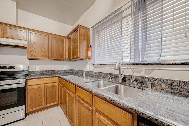 kitchen with stone counters, sink, light tile patterned floors, and stainless steel stove