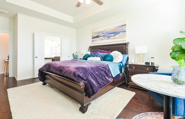 bedroom with a raised ceiling, crown molding, ensuite bath, ceiling fan, and dark hardwood / wood-style flooring