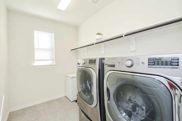 washroom with washing machine and clothes dryer and light tile patterned floors