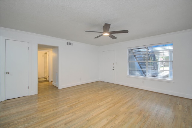 spare room featuring ornamental molding, a textured ceiling, ceiling fan, and light hardwood / wood-style flooring