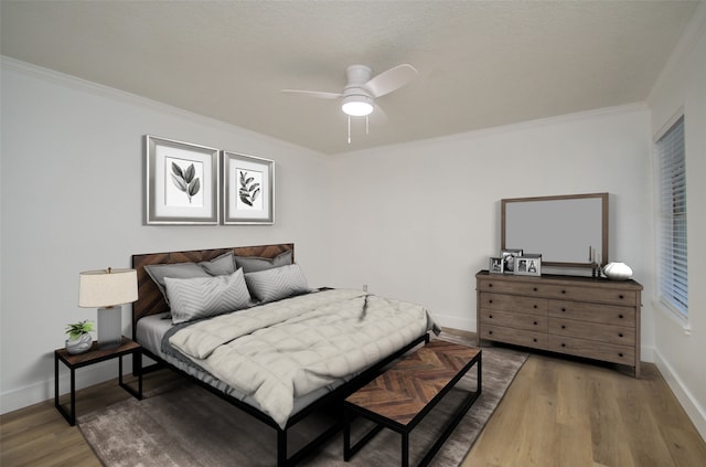 bedroom featuring ceiling fan, ornamental molding, and hardwood / wood-style floors