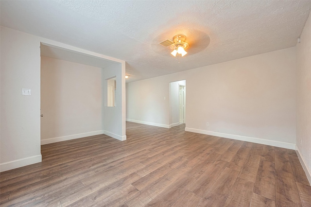 empty room with hardwood / wood-style flooring, ceiling fan, and a textured ceiling