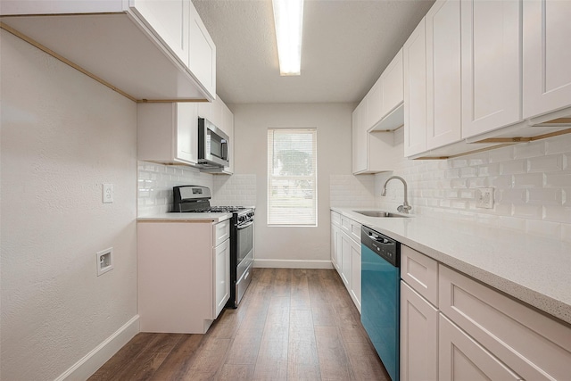 kitchen with white cabinets, stainless steel appliances, dark hardwood / wood-style floors, and sink