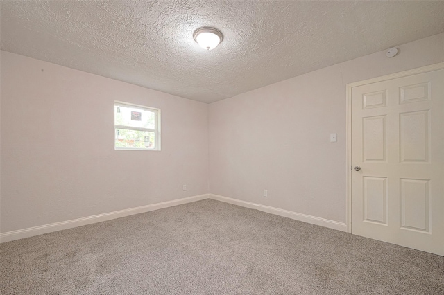 carpeted empty room with a textured ceiling