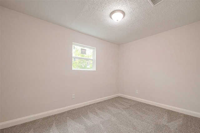 empty room featuring carpet and a textured ceiling