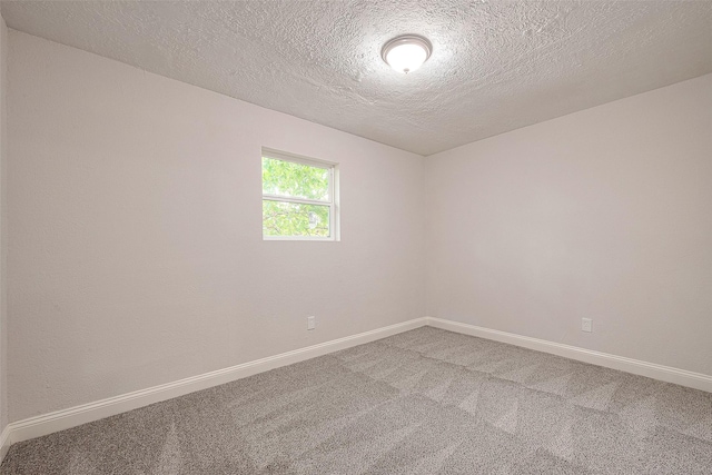 carpeted spare room with a textured ceiling