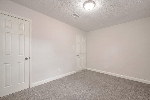 carpeted spare room featuring a textured ceiling