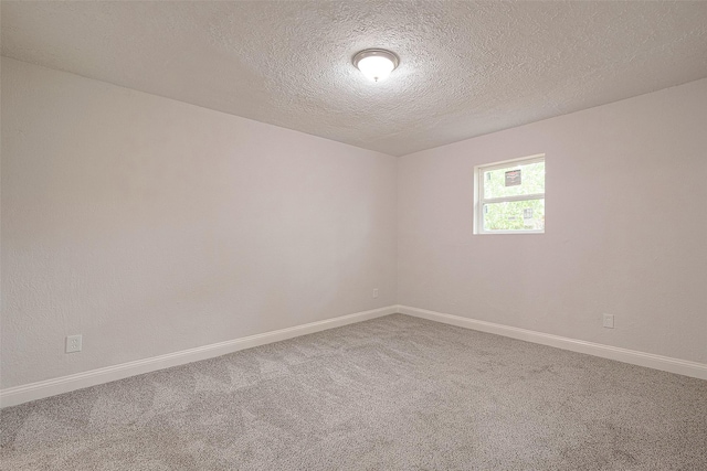 carpeted spare room featuring a textured ceiling